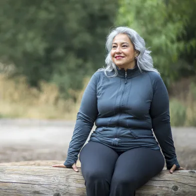 Woman enjoying the outdoors sitting on log